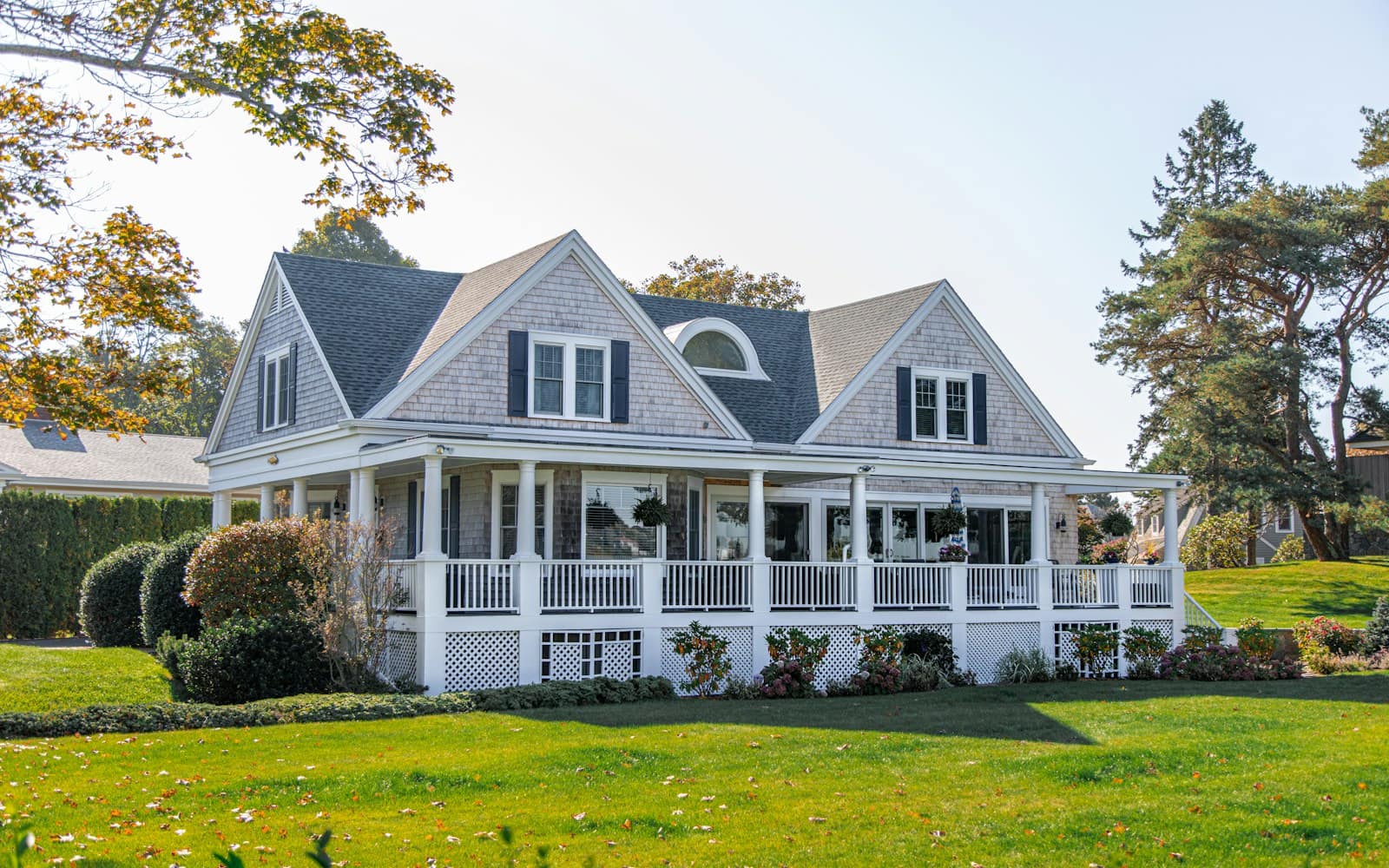 Bright white family home with a wraparound porch, the kind of inherited house heirs often need to decide how to sell